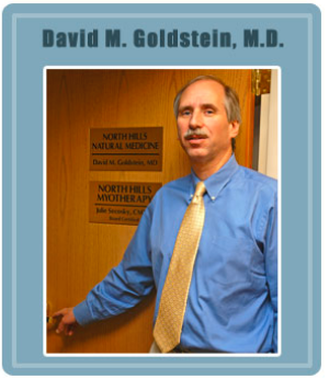 A man in a blue shirt and tie stands by a door with a plaque reading "North Hills Natural Medicine.